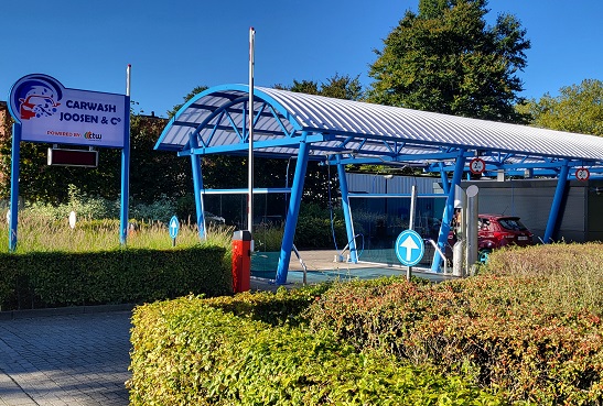 Ingang van Carwash Joosen & C° met blauw-wit reclamebord